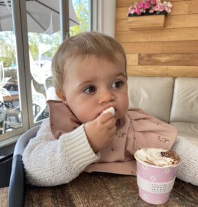 Cute toddler with pink fluffy cup and marshmellows.
